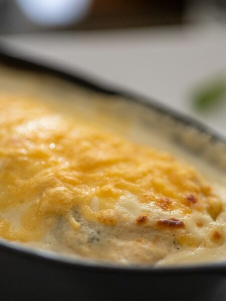 Pirofila con preparazione gratinata al forno, immagine illustrativa per la ricetta delle cicorie gratinate