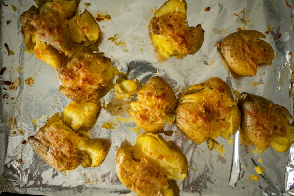 Patate al forno dorate con crosticina di formaggio, fotografia illustrativa della ricetta