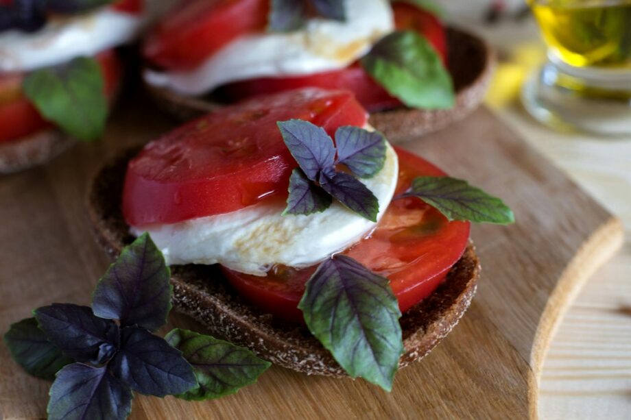 Fette di pane con pomodoro, mozzarella e basilico, immagine illustrativa della Pizza finta